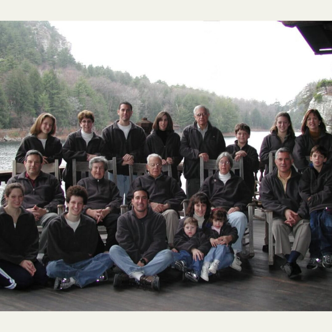 Large family group photo on wooden deck by lake