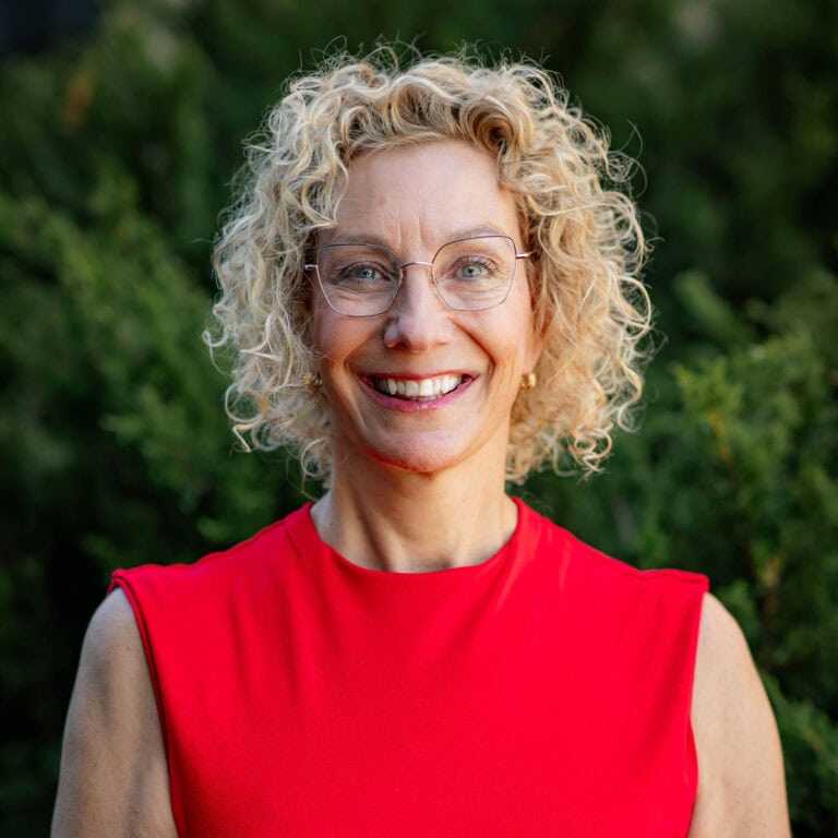 Smiling woman with curly hair wearing red top