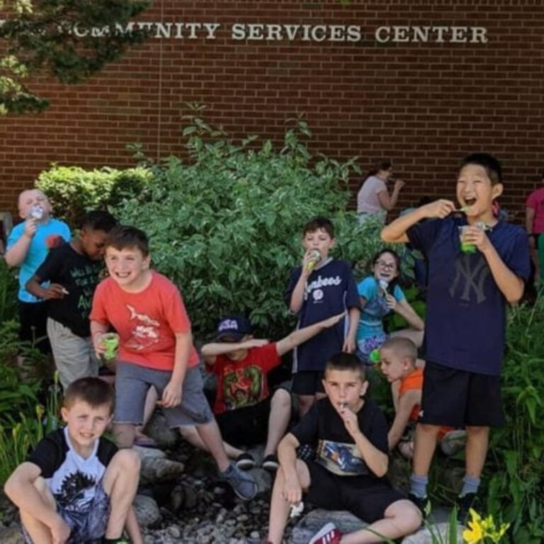 Kids enjoying snacks outside a Community Services Center