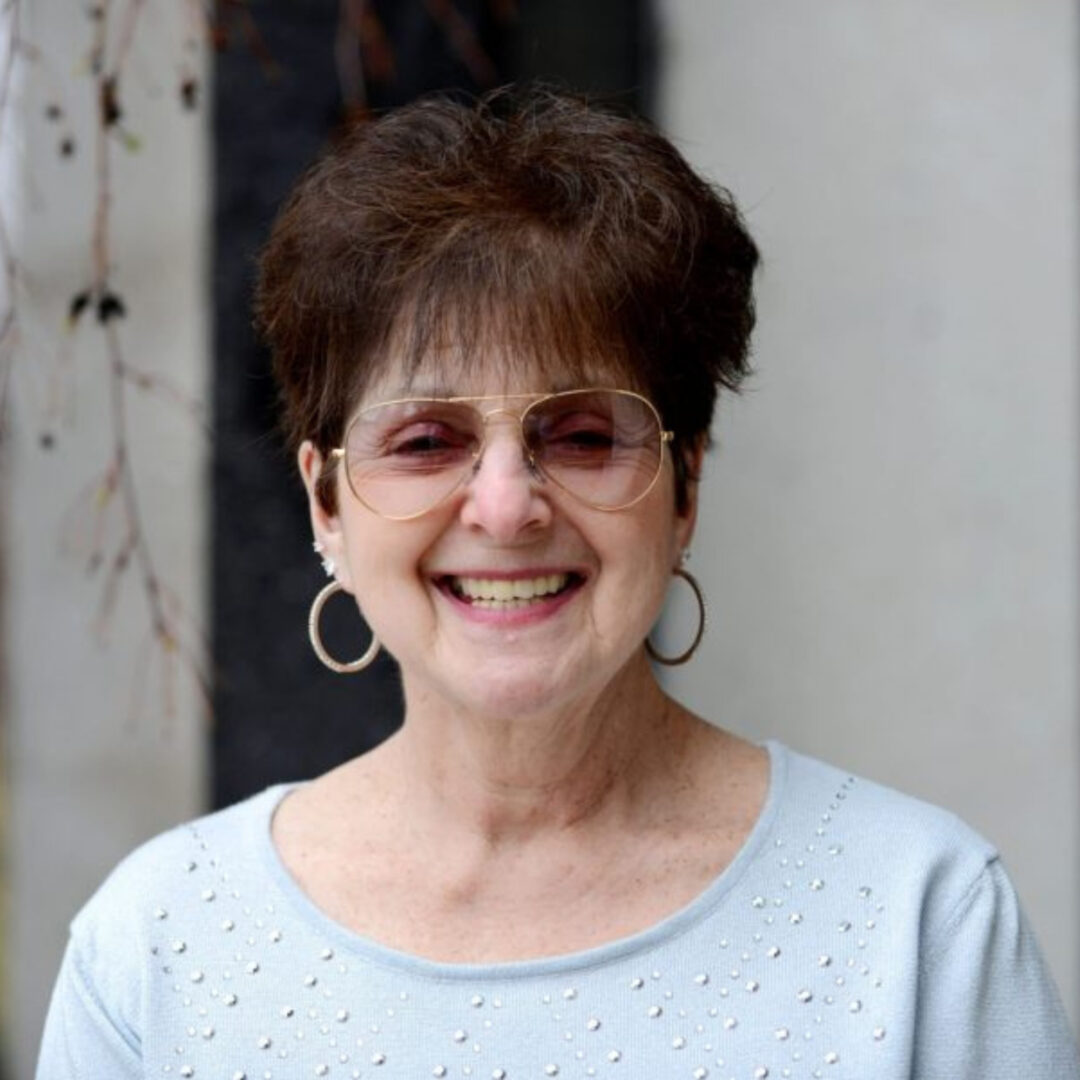 Smiling older woman with glasses and hoop earrings