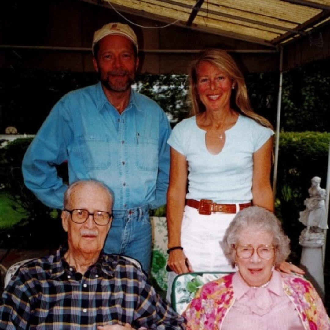 Four family members posing together outdoors under a canopy