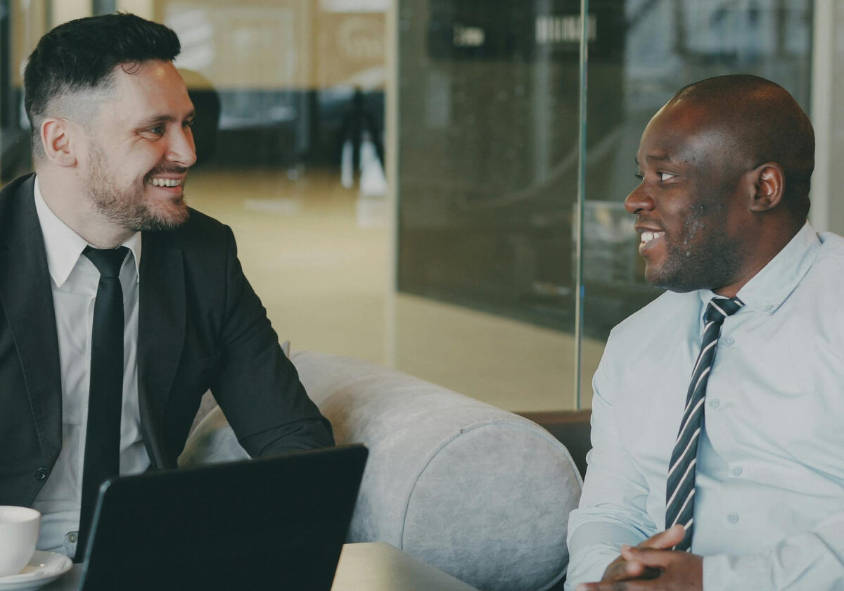 Two businessmen smiling during a professional meeting