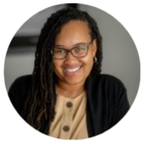 Smiling person with glasses and dreadlocks