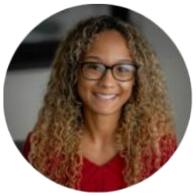 Person smiling with glasses and curly hair