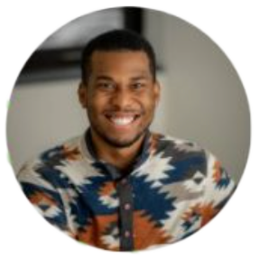 Smiling person in patterned shirt, casual setting.