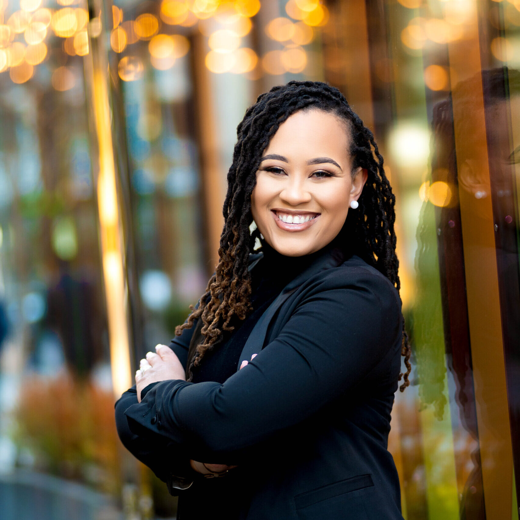 Confident professional woman smiling with arms crossed outdoors