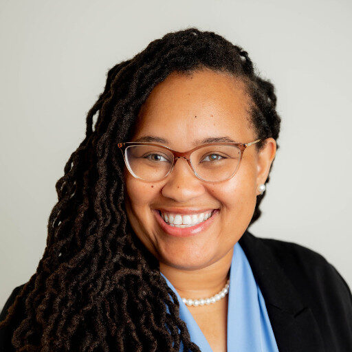 Smiling professional woman with glasses and long locs